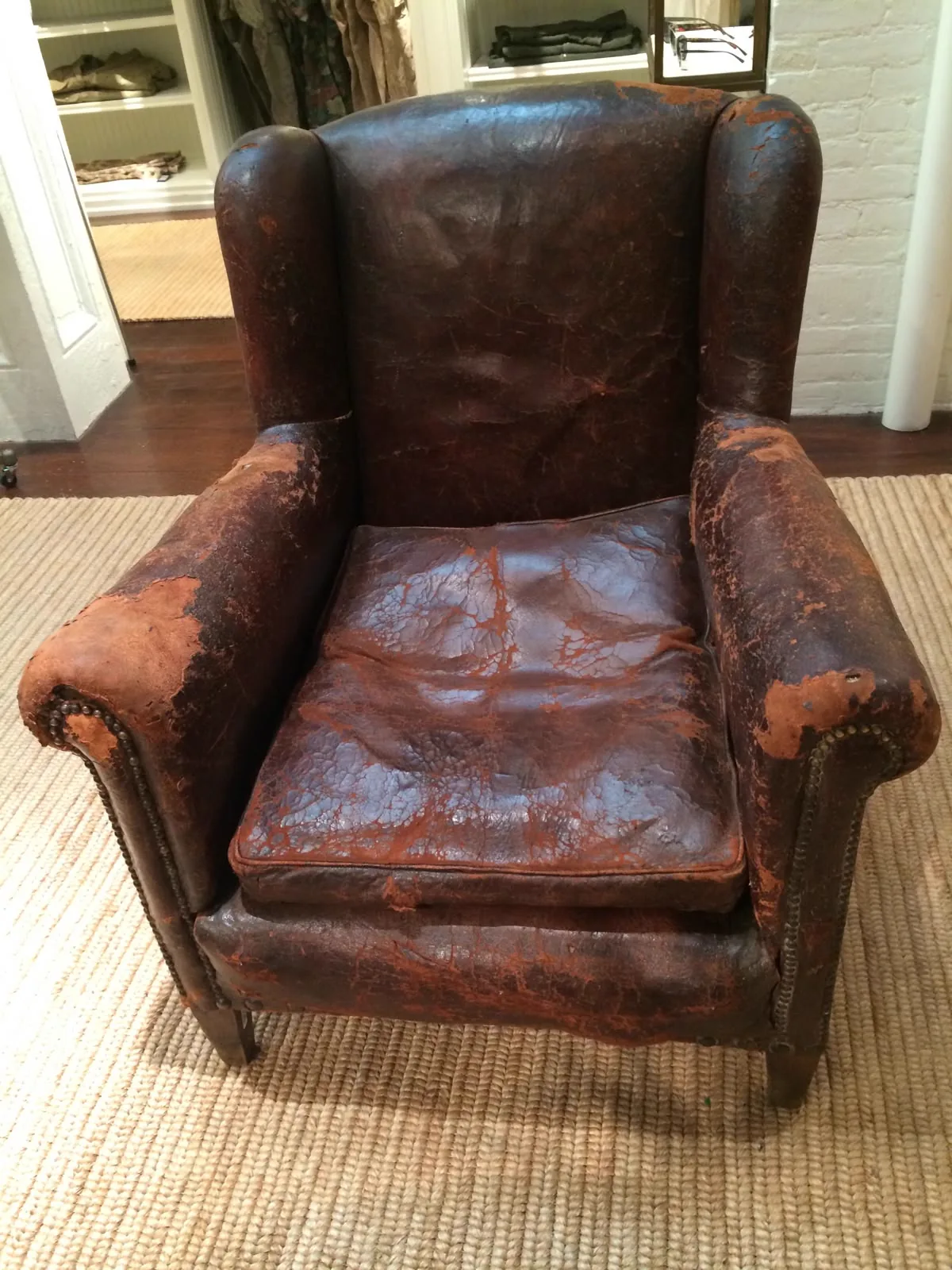 Cracked, worn leather armchair before restoration